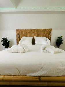 um quarto com uma cama com lençóis brancos e almofadas em BaLille em Lille