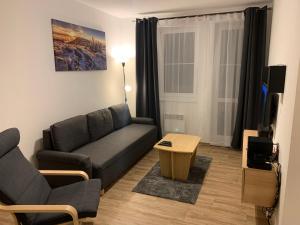 a living room with a couch and a table at Apartmán Horní Mísečky in Vítkovice