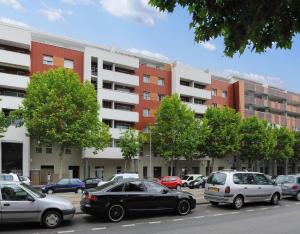 Residhome Clermont Ferrand Gergovia في كليرمون فيران: موقف للسيارات مع وقوف السيارات أمام المباني