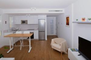 eine Küche und ein Wohnzimmer mit Tisch und Stühlen in der Unterkunft APARTMENT BY THE SEA CALACEITE in Torrox Costa