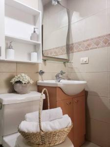 a bathroom with a toilet and a sink and a basket at Ecusuites TorreSol I Parking Trade Center - Gye Airport in Guayaquil