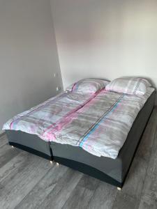 a large bed in a room with a wooden floor at Apartamenty Bezrzecze in Szczecin