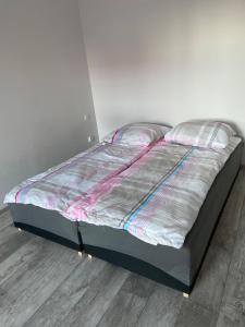 een groot bed in een kamer met een houten vloer bij Apartamenty Bezrzecze in Szczecin