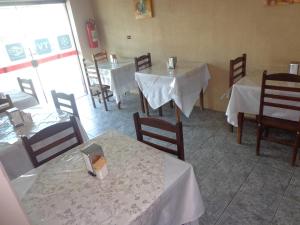 een restaurant met tafels en stoelen met witte tafelkleden bij Hotel em SBO - Centro in Santa Bárbara dʼOeste