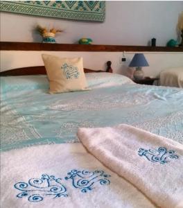 Una cama con dos toallas encima. en Casa Susanna Rural Sardinia, en Sini