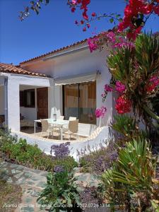 une maison blanche avec une table, des chaises et des fleurs dans l'établissement Schöne Wohnung in Puerto de la Cruz mit Garten., à Puerto de la Cruz