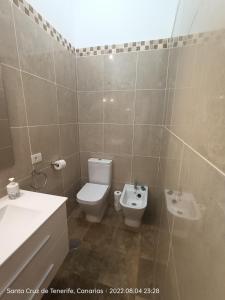 een badkamer met een wit toilet en een wastafel bij Schöne Wohnung in Puerto de la Cruz mit Garten. in Puerto de la Cruz