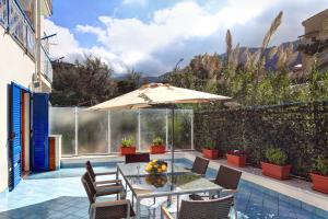 a patio with an umbrella and a table and chairs at Caruso 3 - Sorrento in Sorrento