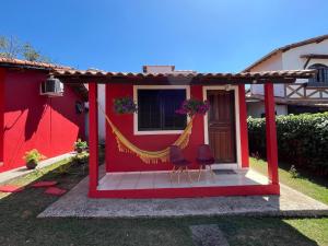 a red house with two chairs in front of it at Vila Noel Centro in Penedo
