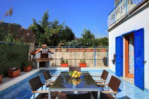 a patio with a table with chairs and a bowl of fruit at Caruso 3 - Sorrento in Sorrento