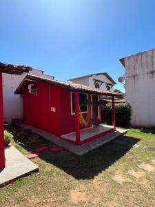 a red house with a hammock in the yard at Vila Noel Centro in Penedo