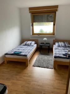 a bedroom with two beds and a window at Palms Zimmer in Frechen