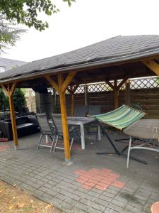a picnic table and a hammock under a pavilion at Palms Zimmer in Frechen