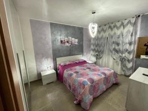 ein Schlafzimmer mit einem Bett mit einer rosa Decke in der Unterkunft Casa VACANZE ONELIA in Gualdo Tadino