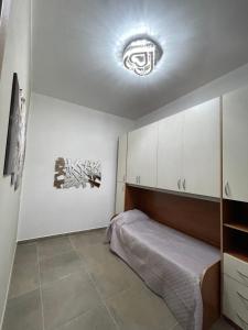 ein Schlafzimmer mit einem Bett und einem Licht an der Decke in der Unterkunft Casa VACANZE ONELIA in Gualdo Tadino