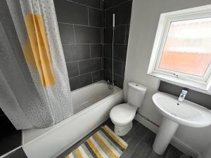 a bathroom with a white toilet and a sink at AMAZING 8 person 4 bedroom and 2 bathroom MEGA house! in Hull