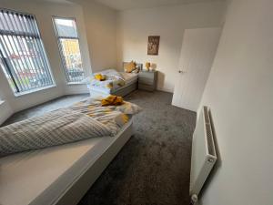two beds in a room with two windows at AMAZING 8 person 4 bedroom and 2 bathroom MEGA house! in Hull