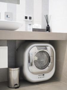 a washing machine in a bathroom under a sink at Apartman Grey in Prague