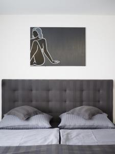a bed with a picture of a woman sitting on it at Apartman Grey in Prague