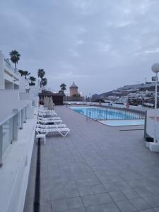 une rangée de chaises longues sur le toit d'un bâtiment dans l'établissement Luxury apartment in Puerto Rico -Gran Canaria, à Mogán