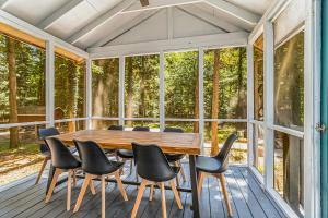 a screened in porch with a wooden table and chairs at The Chalet at Warren Dunes in Sawyer