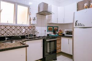 a kitchen with a sink and a refrigerator at VARANDA GOURMET c churrasqueira-3 quartos- Wi-fi in Bertioga