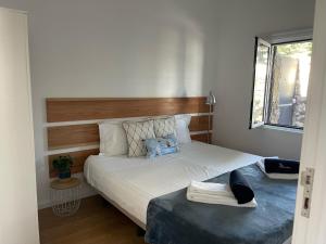 sypialnia z białym łóżkiem z drewnianym zagłówkiem w obiekcie Vacas Felizes Villas - Casa do Badalo w mieście Rabo de Peixe