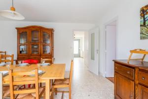 eine Küche und ein Esszimmer mit einem Holztisch und Stühlen in der Unterkunft Nice house with a yard - La Rochelle - Welkeys in Puilboreau