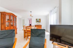 ein Wohnzimmer mit einem TV und einem Esszimmer in der Unterkunft Nice house with a yard - La Rochelle - Welkeys in Puilboreau