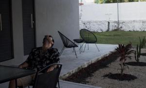 Ein Mann sitzt auf einem Stuhl an einem Tisch in der Unterkunft Türk in Chetumal
