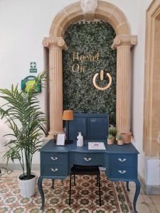 a blue desk in front of a wall with a clock at Hostel On in Sliema