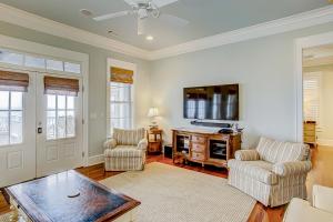 Una sala de estar con dos sillas y un televisor de pantalla plana. en Ocean Elegance, en Edisto Beach