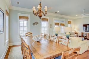 Un comedor con mesa y sillas de madera. en Ocean Elegance, en Edisto Beach