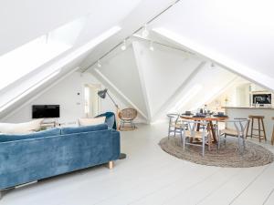 a living room with a blue couch and a table at Linham Barn in Kingsbridge