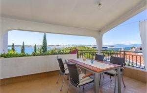 a dining room with a table and chairs on a balcony at Cozy Apartment In Omisalj With Wifi in Omišalj