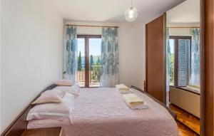 1 dormitorio con cama con sábanas rosas y ventana en Lovely Apartment In Omisalj With House Sea View, en Omišalj