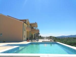 uma piscina em frente a uma casa em Villa Scolopax rusticola Skradin with heated pool em Skradin