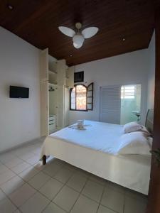 a bedroom with a large white bed with a ceiling at Giprita Wellness Hotel Ubatuba in Ubatuba