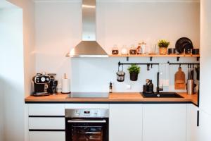a kitchen with white cabinets and a stove at Albatross Dimants - apartamenti Rīgas jūras līča krastā in Ķesterciems +35 photos