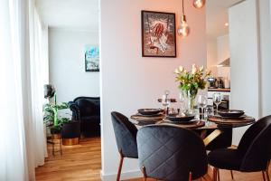 a dining room and living room with a table and chairs at Albatross Dimants - apartamenti Rīgas jūras līča krastā in Ķesterciems