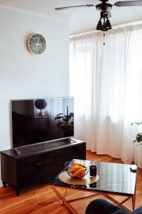 a living room with a coffee table and a clock at Albatross Dimants - apartamenti Rīgas jūras līča krastā in Ķesterciems