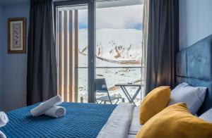 1 dormitorio con 1 cama y vistas a una montaña nevada en Atrium New Gudauri en Gudauri