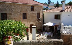 a courtyard of a house with tables and chairs at Casa Duas Fontes in Capinha