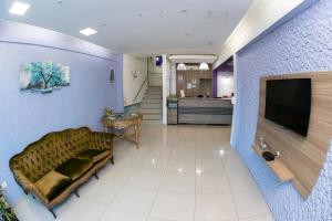 un soggiorno con divano e TV di Aeroporto Plaza Hotel a Campo Grande