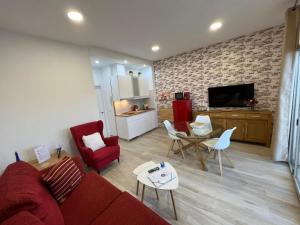 a living room with a red couch and a table at Vistas Melenara by CanariApartment - Beachfront Apartments with Balcony and Fast WiFi in Telde