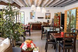 a restaurant with tables and chairs and plants at Casa María Aeropuerto B&B in Alajuela +45 photos