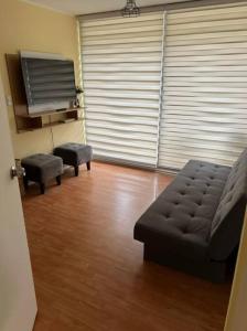 a living room with a couch and two stools at Amplio Depto en Viña del Mar con Estacionamiento. in Viña del Mar