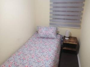 a small bedroom with a bed and a table at Amplio Depto en Viña del Mar con Estacionamiento. in Viña del Mar