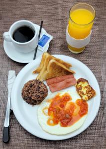 a plate of breakfast food with eggs toast and a cup of coffee at Hotel RDG in Managua