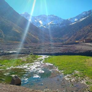 un arc-en-ciel sur un champ avec des montagnes en arrière-plan dans l'établissement Atlas Views, à Imlil